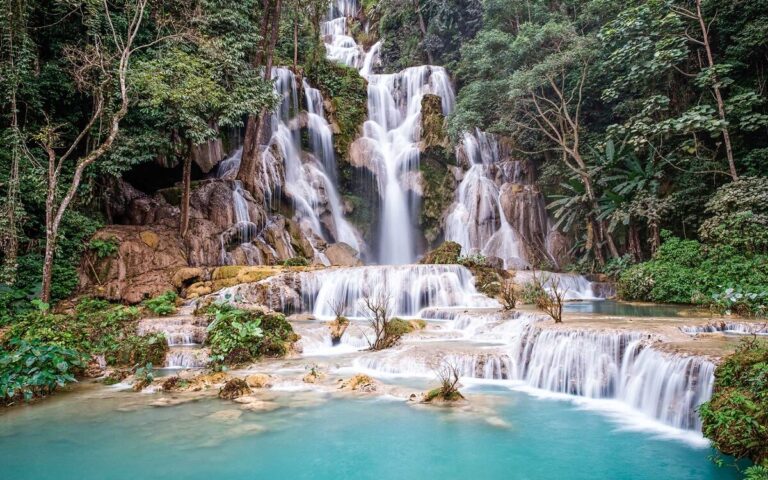 Tiered Kuang Si waterfalls surrounded by forest near Luang Prabang