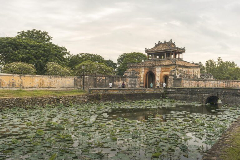 Historic gateway beyond a moat with water plants at Hue Citadel, Vietnam
